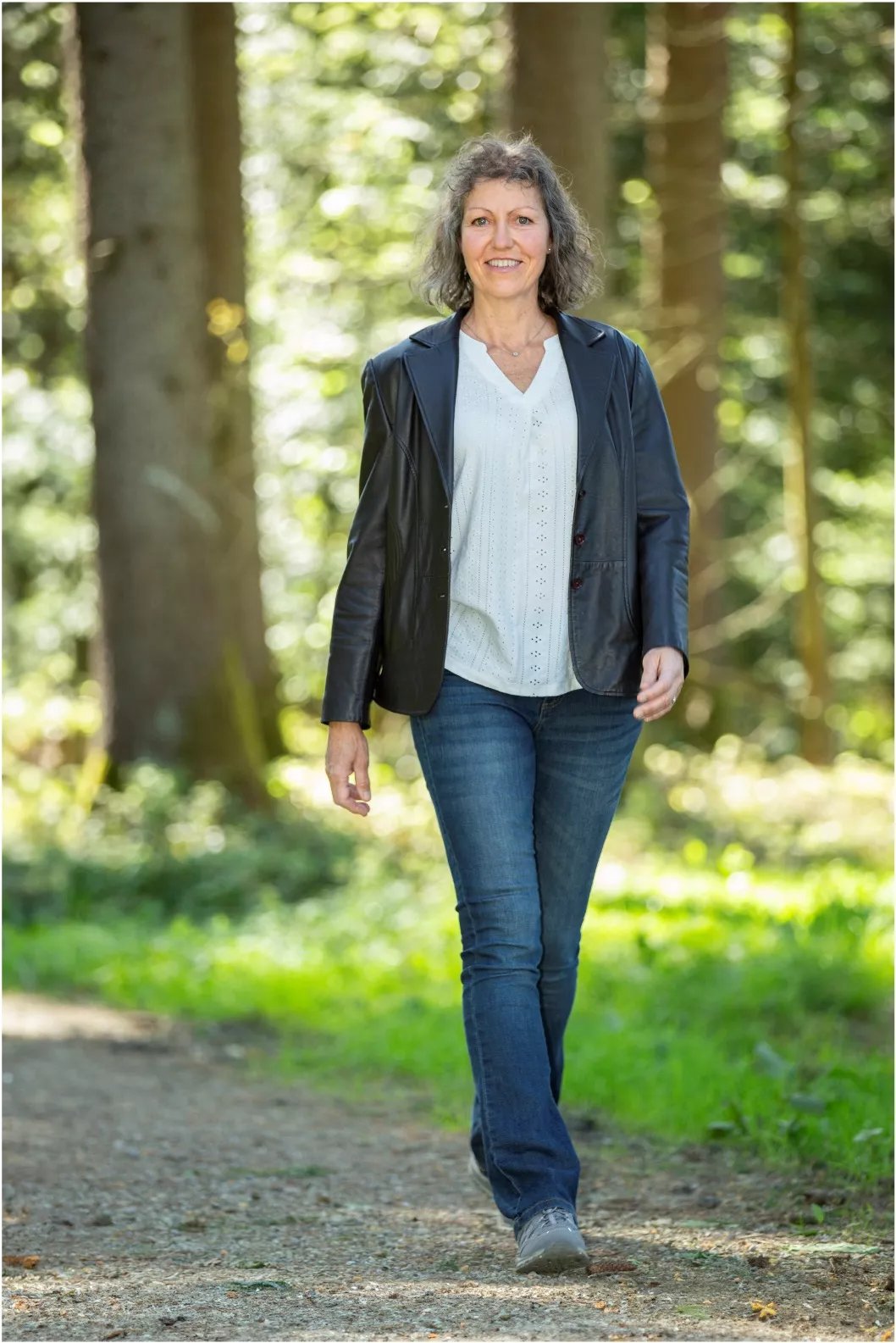 Sabine Junginger geht in dunkler Jacke durch den Wald